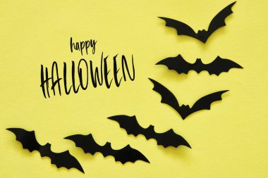 Cadılar Bayramı tatil kavramı. Sarı zemin üzerinde siyah yarasalar. Üstten görünüm, düz yatıyordu