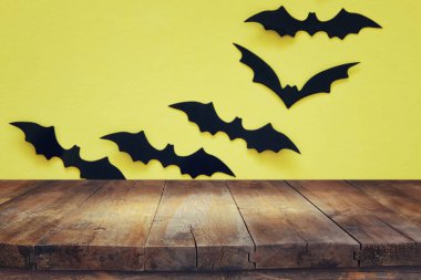 Cadılar Bayramı tatil kavramı. Siyah yarasalar arka plan önünde boş rustik tablo. Ürün görüntü montaj için hazır