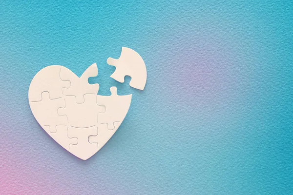 stock image Top view image of paper white heart puzzle with missing piece over blue background. Health care, donate, world heart day and world health day concept