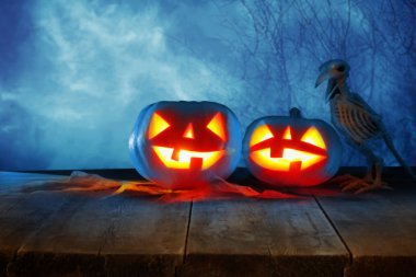 Cadılar Bayramı tatil kavramı. Gece korkunç, perili ve sisli orman, ahşap masa üzerinde boş rustik masa Pumpkins önünde. Ürün görüntü montaj için hazır