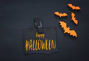 Cadılar Bayramı tatil harfle metin mutlu Halloween ahşap siyah arka plan üzerinde en az üstten görünüm görüntüsü. Kartı ve davetiye kavramı