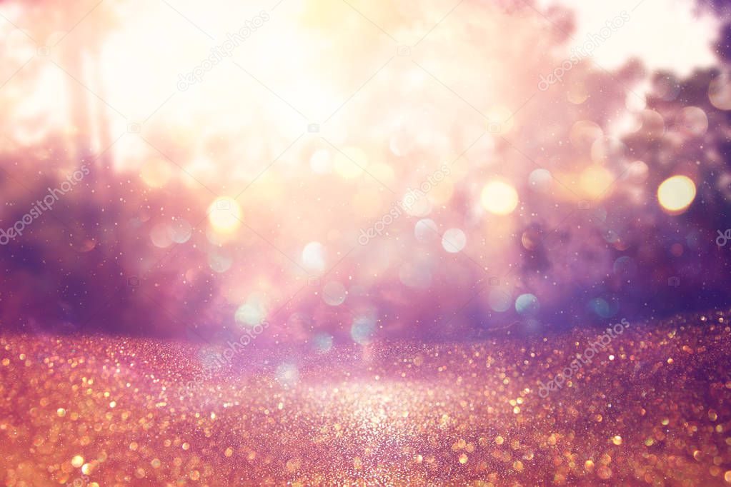 blurred abstract photo of light burst among trees and glitter golden bokeh lights