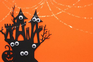 Cadılar Bayramı tatil kavramı. turuncu arka plana perili cadı evi. Üstten görünüm, düz yatıyordu