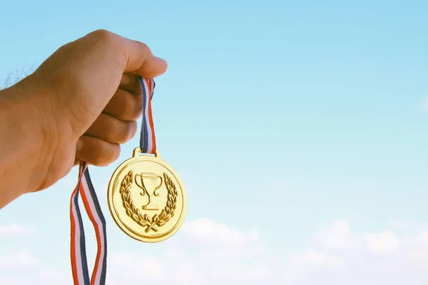 Mano Hombre Levantada Sosteniendo Medalla Oro Contra Cielo Premio Concepto — Foto de Stock