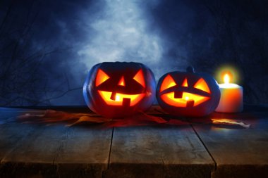 Cadılar Bayramı tatil kavramı. Gece korkunç, perili ve sisli orman, ahşap masa üzerinde boş rustik masa Pumpkins önünde. Ürün görüntü montaj için hazır