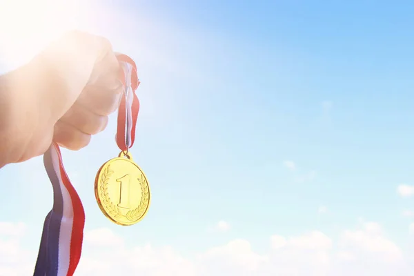 Mano Hombre Levantada Sosteniendo Medalla Oro Contra Cielo Premio Concepto — Foto de Stock