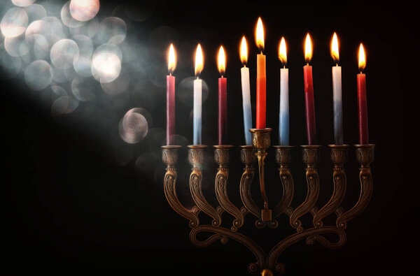 Low key Image of jewish holiday Hanukkah background with menorah (traditional candelabra) and burning candles