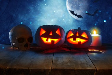 Cadılar Bayramı tatil kavramı. Gece korkunç, perili ve sisli orman, ahşap masa üzerinde boş rustik masa Pumpkins önünde. Ürün görüntü montaj için hazır