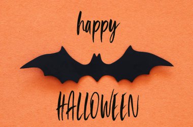 Cadılar Bayramı tatil kavramı. Turuncu arka plan üzerinde siyah yarasalar. Üstten görünüm, düz yatıyordu