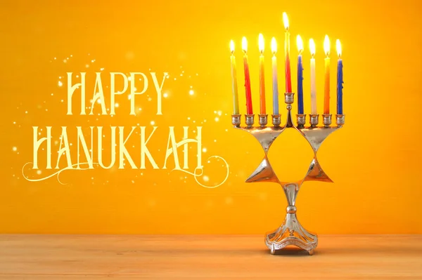 image of jewish holiday Hanukkah background with menorah (traditional candelabra) and burning candles