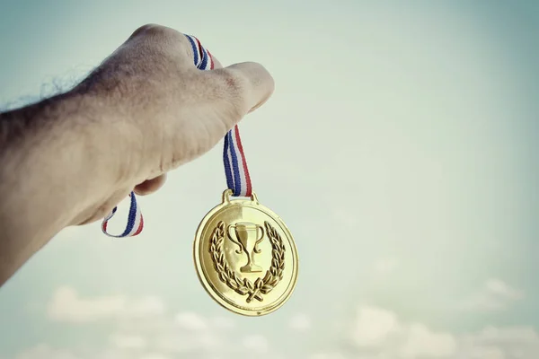 Mano Hombre Levantada Sosteniendo Medalla Oro Contra Cielo Premio Concepto — Foto de Stock