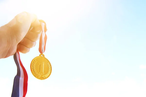 Man Hand Opgeheven Met Gouden Medaille Tegen Lucht Award Overwinningsconcept — Stockfoto