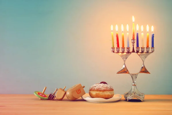 image of jewish holiday Hanukkah background with traditional spinnig top, menorah (traditional candelabra) and burning candles