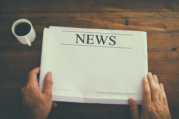 верхний вид изображения мужской руки, держащей пустую газету с пустым местом, чтобы добавить новости или текст. изображение в стиле ретро
