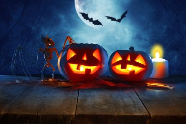 Cadılar Bayramı tatil kavramı. Gece korkunç, perili ve sisli orman, ahşap masa üzerinde boş rustik masa Pumpkins önünde. Ürün görüntü montaj için hazır