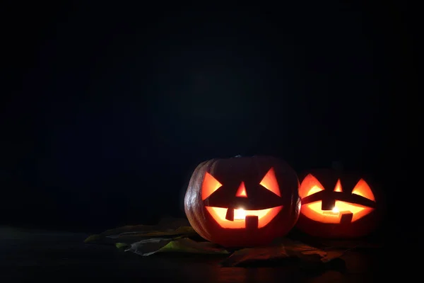 Concept van Halloween vakantie. Pompoenen over houten tafel bij nacht eng, achtervolgd en mistige bos — Stockfoto