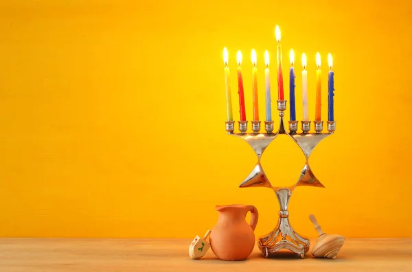 image of jewish holiday Hanukkah background with menorah (traditional candelabra) and burning candles