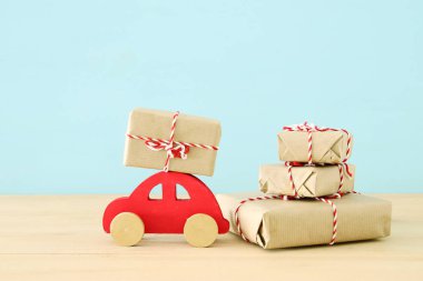 Bir Noel hediyesi taşıyan ahşap kırmızı araba.