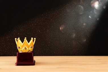Tahta masanın üzerinde altın taç resmi.