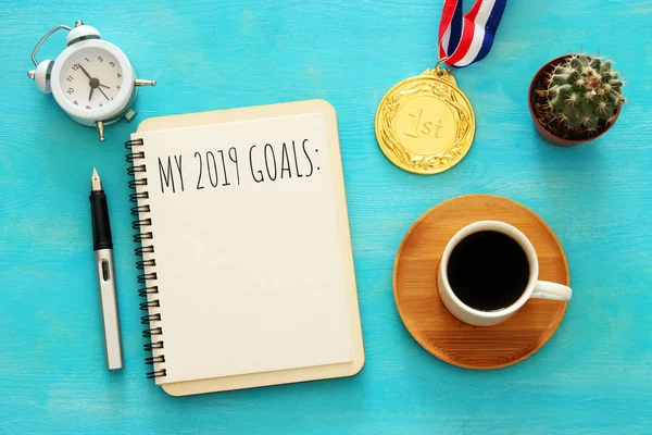 Top view 2019 goals list with notebook, cup of coffee over wooden desk. — Stock Photo, Image