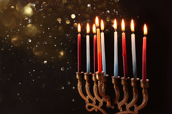 Low key Image of jewish holiday Hanukkah background with menorah (traditional candelabra) and burning candles