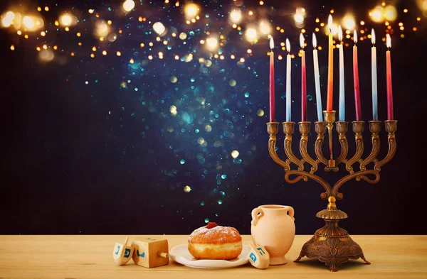 image of jewish holiday Hanukkah background with menorah (traditional candelabra) and candles over glitter shiny background