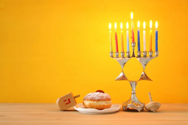 image of jewish holiday Hanukkah background with traditional spinnig top, menorah (traditional candelabra) and burning candles