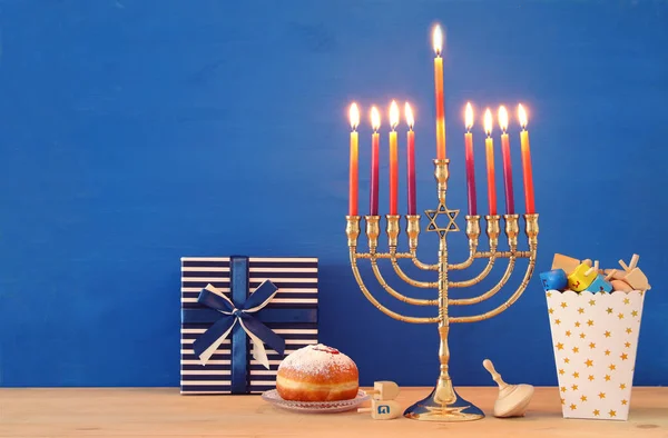 Afbeelding van Joodse vakantie Hanukkah achtergrond met traditionele spinnig top, menora (traditionele kandelaar) en brandende kaarsen. — Stockfoto