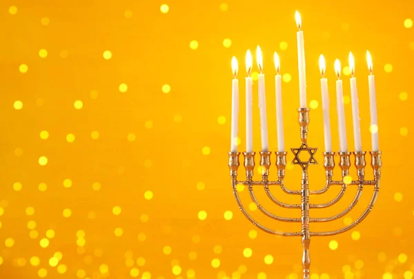 image of jewish holiday Hanukkah background with menorah (traditional candelabra) and candles.