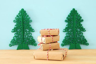 görüntü el yapımı hediye kutuları ahşap masa üzerinde sarılı.