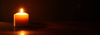 Siyah arka plan üzerinde yanan mumlar.