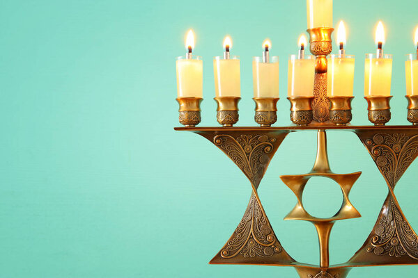 Image of jewish holiday Hanukkah background with menorah (traditional candelabra) and burning candles