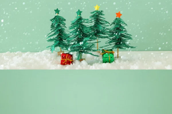 Bilden av papper julgranar över vit snö. — Stockfoto