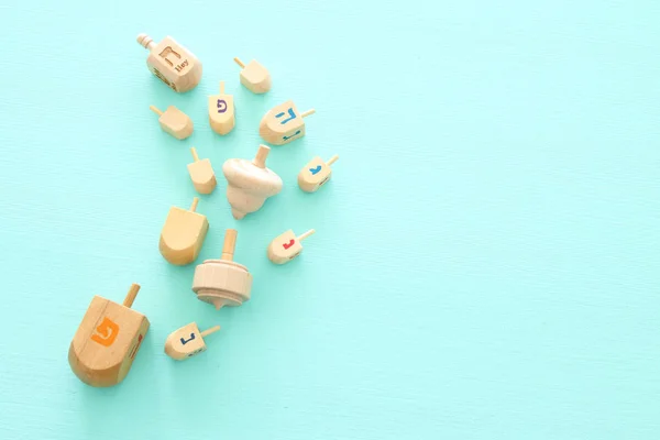 Image of jewish holiday Hanukkah with wooden dreidels colection (spinning top) over mint background