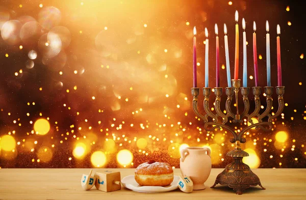 image of jewish holiday Hanukkah background with menorah (traditional candelabra) and candles over glitter shiny background