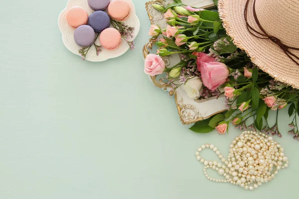 Stock image plate of macaroons over wooden table and flowers