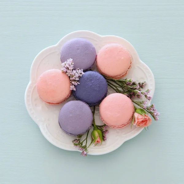 Vue de dessus du macaron coloré ou du macaron sur fond bleu pastel. Pose plate . — Photo