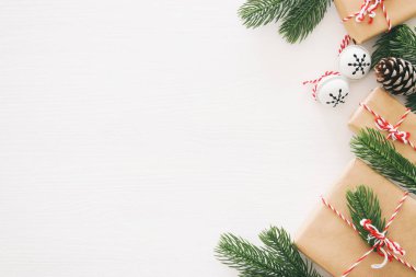 Çam kozalakları, çam dalları ve ahşap beyaz arka plan üzerinde hediyeler Noel arka plan. Düz yatıyordu, en iyi görünümü