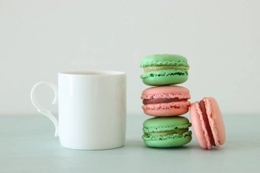 Beyaz vintage fincan kahve ve renkli macaron ya da pastel ahşap masa üzerinde acıbadem kurabiyesi