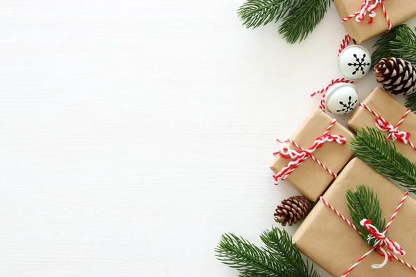Weihnachtlicher Hintergrund Mit Tannenzapfen Tannenzweigen Und Geschenken Über Weißem Holzgrund — Stockfoto