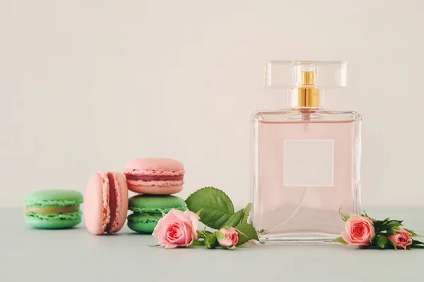 Imagen Frasco Perfume Con Flores Pétalos Rosa Macarrones Sobre Mesa — Foto de Stock