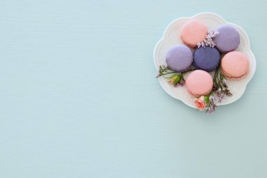 Üstten görünüm renkli macaron veya pastel mavi arka plan üzerinde acıbadem kurabiyesi. Düz yatıyordu