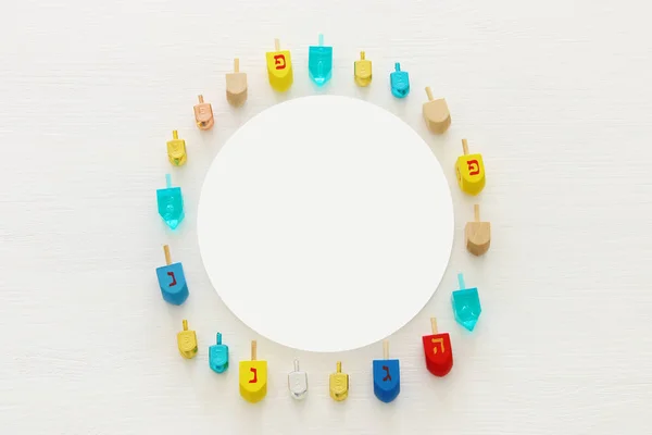 Image of jewish holiday Hanukkah with wooden dreidels colection (spinning top) over white background