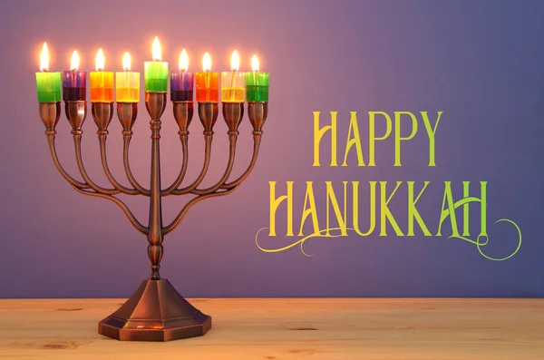 image of jewish holiday Hanukkah background with menorah (traditional candelabra) and colorful oil candles