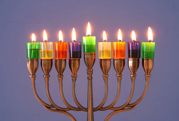 image of jewish holiday Hanukkah background with menorah (traditional candelabra) and colorful oil candles