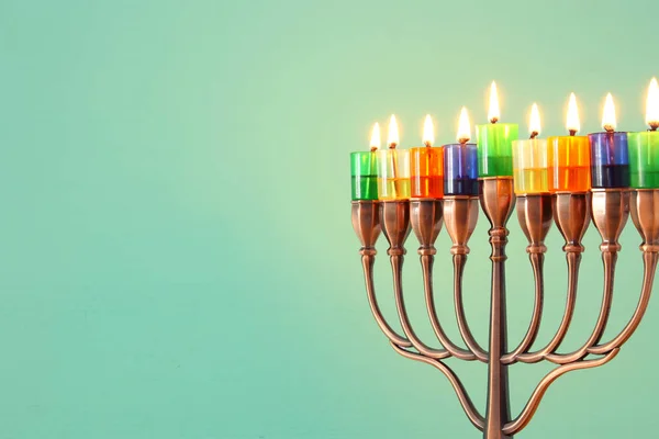 image of jewish holiday Hanukkah background with menorah (traditional candelabra) and colorful oil candles