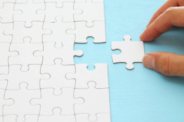 Erkek eli bulmacanın son parçasını koyuyor.