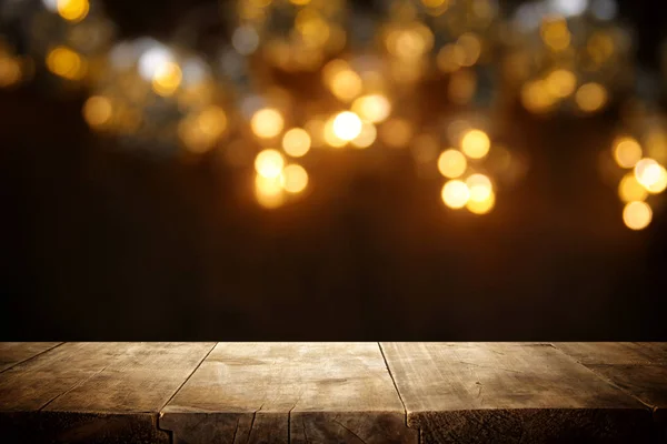 キラキラ黒と金の前で素朴な木製のテーブル ライト — ストック写真