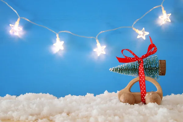 Coche Madera Que Lleva Árbol Navidad Frente Fondo Azul —  Fotos de Stock