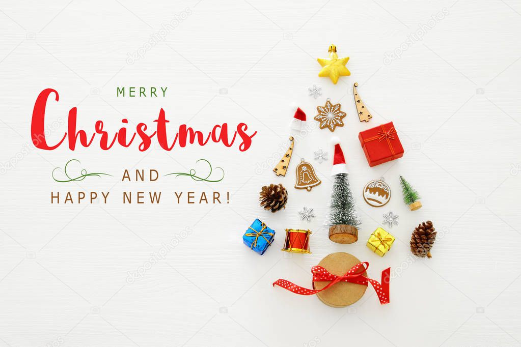 Top view image of festive decorations in shape of christmas tree over white wooden background. Flat lay